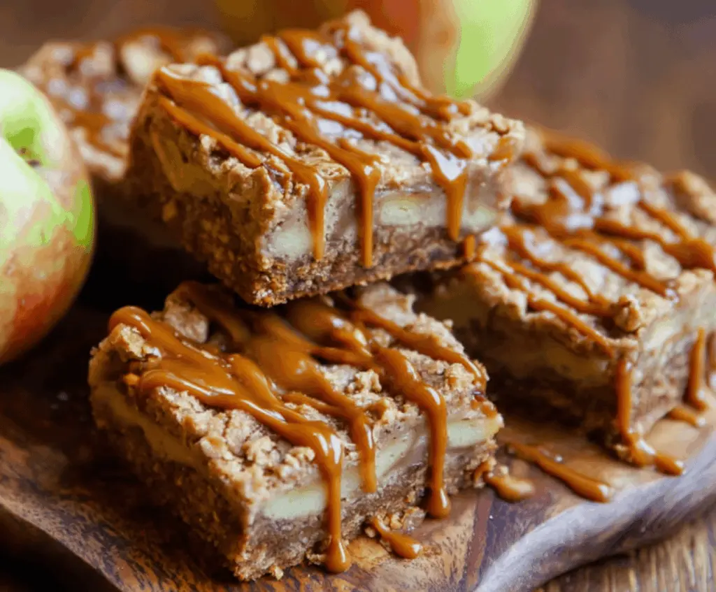 Delicious salted caramel apple bars with a golden crust, topped with caramel sauce and sliced apples, perfect for fall desserts.